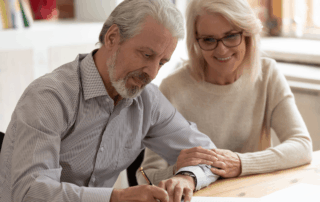 couple signing will with testamentary trust giving asset protection using estate planning