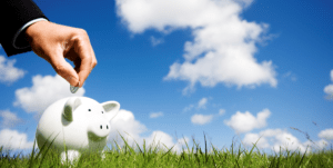 piggybank below a bright but clouded sky with suited man making a deposit